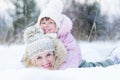 Happy parent and kid playing with snow in winter