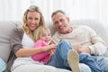 Happy parent tickling their cute daughter on the couch