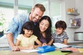 Happy parents assisting children doing homework Royalty Free Stock Photo