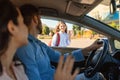 Happy parents bringing their daughter to school, sitting in car and waving hands to child girl