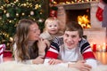 Happy parents and child boy have a fun near Christmas tree at home. Father, mother, son celebrating New Year together Royalty Free Stock Photo