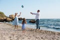 Happy parents with child have a rest playing ball near sea Royalty Free Stock Photo