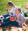 Father, mother, daughter and son enjoy eating watermelon at picnic in park in summer Royalty Free Stock Photo