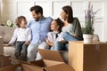 Happy parents with children relaxing on sofa on moving day