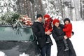 Happy parents with children in woods by auto with a Christmas tree. Royalty Free Stock Photo