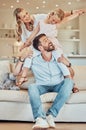 Happy parents and cute daughter at home. Adorable caucasian girl smiling and sitting on fathers shoulders with arms Royalty Free Stock Photo