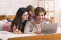 Happy Parents And Cute Little Daughter Using Laptop In Bed Together Royalty Free Stock Photo