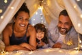 Happy parents with daughter have fun in cozy tent Royalty Free Stock Photo