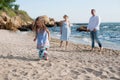 Happy parents with daughter have a rest playing ball near sea Royalty Free Stock Photo