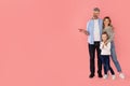 Happy Parents And Daughter Pointing Finger Aside On Pink Background