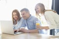 Happy parents with daughter using laptop at home Royalty Free Stock Photo