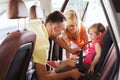 Happy parents fastening child with car seat belt Royalty Free Stock Photo
