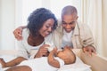 Happy parents feeding their baby boy in his crib Royalty Free Stock Photo