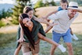 Happy parents giving their children piggyback ride in summer in nature. Royalty Free Stock Photo