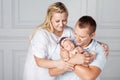 Happy parents holding a cute newborn girl. Mom, dad and baby. Cl Royalty Free Stock Photo