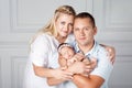 Happy parents holding a cute newborn girl. Mom, dad and baby. Close-up. Portrait of  smiling family with newborn on the hands. Royalty Free Stock Photo