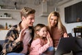 Happy parents with kid daughter waving hands video calling on laptop at home. Royalty Free Stock Photo