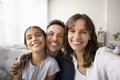 Happy parents and kid looking at camera with toothy smiles Royalty Free Stock Photo