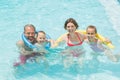 Happy parents and kids having fun in pool Royalty Free Stock Photo