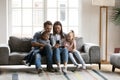 Happy parents with kids relax at home using cellphone Royalty Free Stock Photo