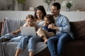 Happy parents with kids using laptop at home together Royalty Free Stock Photo
