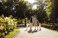 Happy parents kiss. Family with little kids at the park, loving dad hold in arms adorable daughter, beautiful mom hold Royalty Free Stock Photo