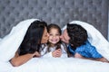 Happy parents kissing daughter Royalty Free Stock Photo