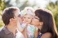 Parents kissing their baby on the cheek in the Park Royalty Free Stock Photo