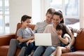 Happy parents with little daughter and son using laptop. Royalty Free Stock Photo