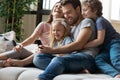 Happy parents with little kids use cellphone at home Royalty Free Stock Photo