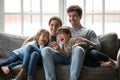 Happy parents with little kids using smartphone at home Royalty Free Stock Photo