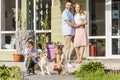 happy parents looking at children playing with dog Royalty Free Stock Photo