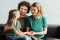 happy parents looking at cute little daughter while sitting on couch Royalty Free Stock Photo