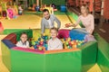 happy parents looking at cute little kids smiling at camera while sitting in pool Royalty Free Stock Photo