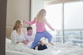 Happy parents looking at playful children in bedroom