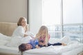 Happy parents looking at playful children in bedroom