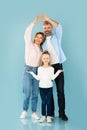 Happy Parents Making Fingers Heart Above Their Daughter, Blue Background