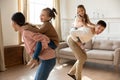 Happy parents with children playing funny game in living room Royalty Free Stock Photo