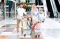 Happy Parents Riding Little Daughter In Shopping Cart In Mall