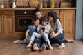 Happy parents with small kids use cellphone in kitchen Royalty Free Stock Photo