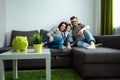 Happy parents and son having fun, tickling sitting together on the sofa, cheerful couple laughing, playing a game with their son, Royalty Free Stock Photo