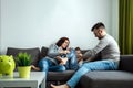 Happy parents and son having fun, tickling sitting together on the sofa, cheerful couple laughing, playing a game with their son, Royalty Free Stock Photo