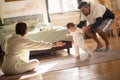 Happy parents teaching baby son to walk in bedroom Royalty Free Stock Photo