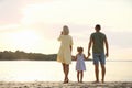 Happy parents with their child on beach, back view. Spending time in nature Royalty Free Stock Photo