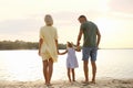 Happy parents with their child on beach, back view. Spending time in nature Royalty Free Stock Photo