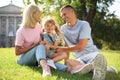Happy parents with their child having fun on green grass. Spending time in nature Royalty Free Stock Photo
