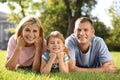 Happy parents with their child having fun on green grass. Spending time in nature Royalty Free Stock Photo