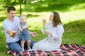 Happy parents and their child are having fun together outdoors, blowing bubbles. Smiling family with toddler enjoying Royalty Free Stock Photo