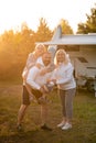 Happy parents with their child playing with a ball near their mobile home in the woods Royalty Free Stock Photo