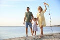 Happy parents with their child playing with kite on beach, space for text. Spending time in nature Royalty Free Stock Photo